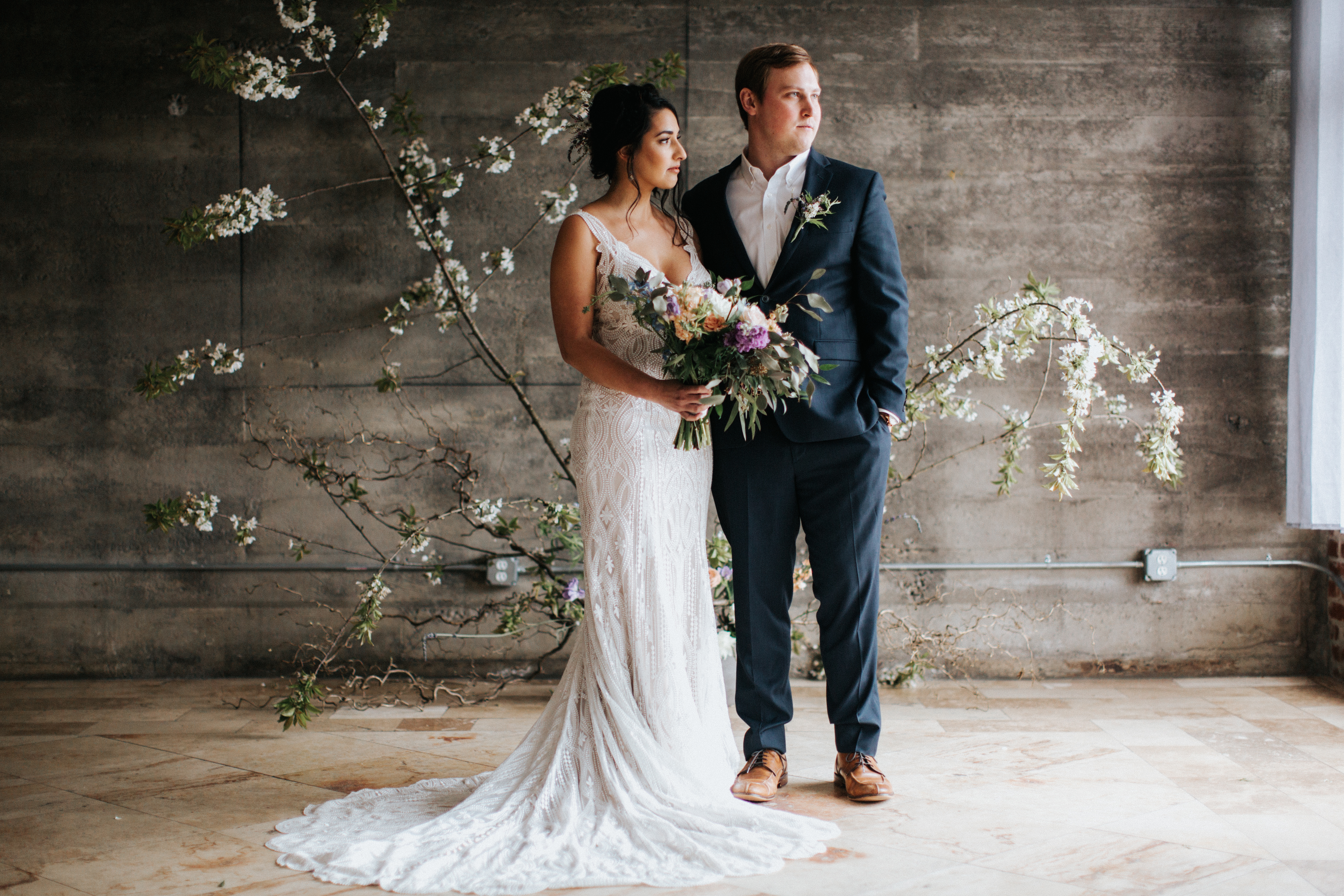 groom and bride holding pastel bridal bouquet