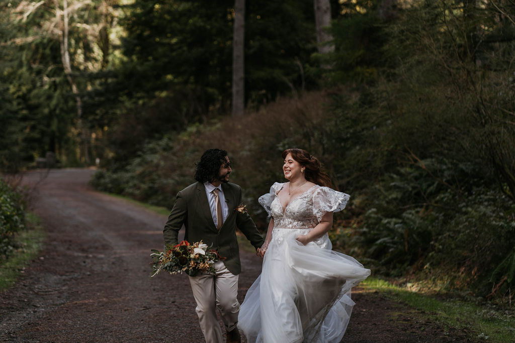 Bride and Groom happily running through the forest at hoyt arboretum 